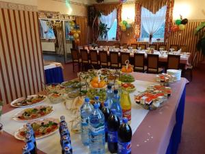 una mesa larga con platos de comida y botellas de agua en Drawa, en Przesieki