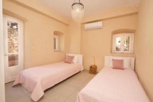 a bedroom with two beds and a chandelier at Mathilda's House in Tselendáta