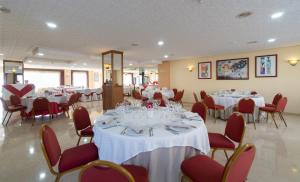 a banquet hall with white tables and red chairs at Rincón Sol in Rincón de la Victoria