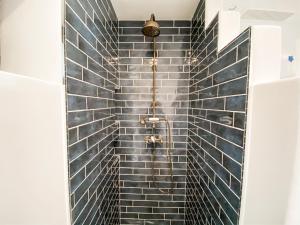 a bathroom with a shower with blue tiles at Vineyard and Views Exquisite Luxury Douro Villa with Sun-Drenched Infinity Pool in Folgosa +27 photos
