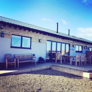 a house with a patio with a table and chairs at Hen Houses with Hot Tubs - Big Drift and Fairchilds Barn in Caldecott