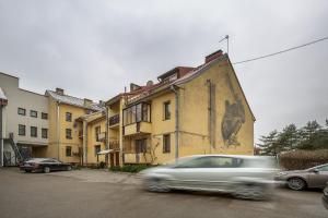 a car driving past a building with a painting on it at Art & Comfort Rooms in Kaunas