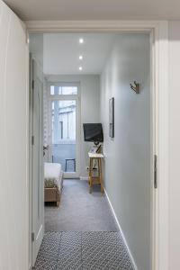 un couloir avec une chambre avec un lit et une porte dans l'établissement Art & Comfort Rooms, à Kaunas