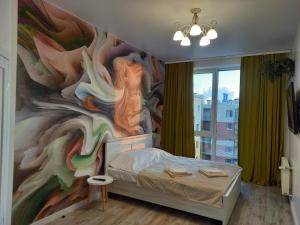 Schlafzimmer mit Wandgemälde in der Unterkunft Апартаменти класу люкс в ЖК Яровиця,1 спальня in Luzk