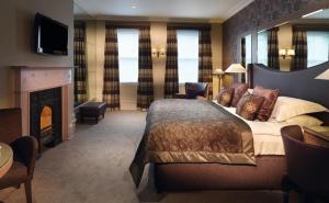 een hotelkamer met een bed en een open haard bij Macdonald Windsor in Windsor