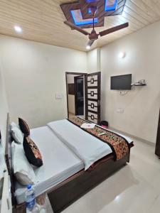 Un dormitorio con una cama grande y un televisor. en Hotel RUJHAN - Just 2 Minute walking Distance From Golden Temple, en Amritsar