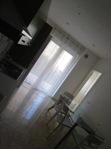 Habitación con mesa de cristal y ventana. en Suite in Città residence en Isernia