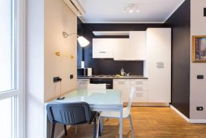 a small kitchen with a blue table and chairs at LUST STUDIO GULLI in Milan
