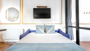a bedroom with a bed with a tv on the wall at Luxury 2 Bedroom - Louvre & Champs Elysees in Paris