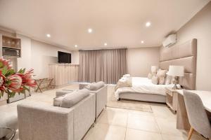 a bedroom with a bed and a living room at ParkHill Luxury Accommodation in Bloemfontein
