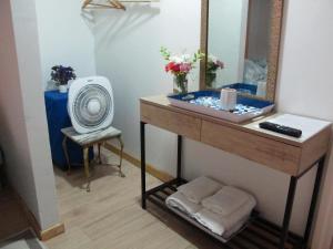 ein Bad mit einem Waschbecken, einem Spiegel und einem Ventilator in der Unterkunft Cabañas Lemupewen Chillán 3 y 4 in Chillán