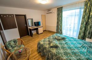 um quarto de hotel com uma cama e uma televisão em Elina em Techirghiol