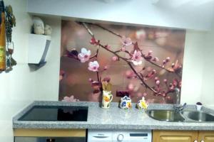 un bancone della cucina con lavandino e un albero con fiori rosa di La casita Azul,apartamento encantador a Frigiliana
