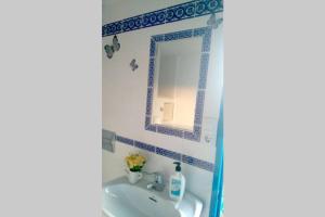 bagno con lavandino e specchio di La casita Azul,apartamento encantador a Frigiliana