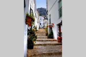 an alley with stairs and potted plants at La casita Azul,apartamento encantador in Frigiliana