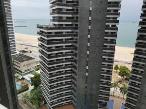 a tall building with the beach in the background at Landscape Residence by Escala Imóveis in Fortaleza