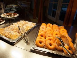 um buffet de donuts e outros produtos de pastelaria no balcão em Gardaland Hotel em Castelnuovo del Garda