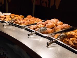 a buffet line with different types of pastries and rolls at Gardaland Hotel in Castelnuovo del Garda