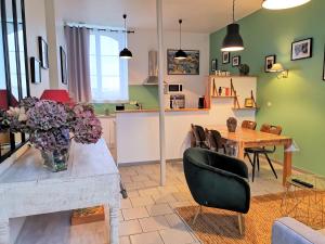 ein Wohnzimmer mit einem Tisch und einer Blumenvase in der Unterkunft La Récréation in Châtelaudren
