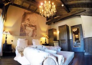 a bedroom with a large bed and a chandelier at Hotel Le Castel in Chamonix-Mont-Blanc