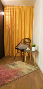 a chair and a table in front of a curtain at Kyriad Hotel Laval in Laval