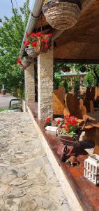 a patio with flowers in baskets and a table at Vila Prezident in Sremski Karlovci