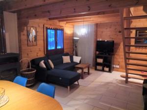 a living room with a couch and a tv at Chalet des Brocards in Saint-Maurice-sur-Moselle