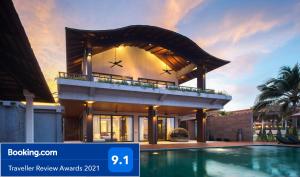 a house with a swimming pool in front of it at Saai Resort in Bang Saphan Noi