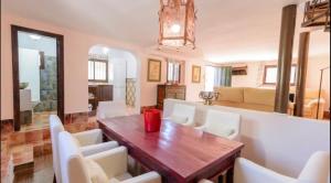 a dining room with a wooden table and white chairs at El Puente in Ronda