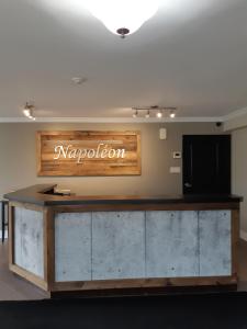a lobby with a reception desk with a marroon sign at Hôtel Napoléon in Angers