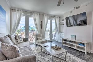 a living room with a couch and a tv at Dazzling Mexico Beach Condo - Walk to the Beach! in Mexico Beach