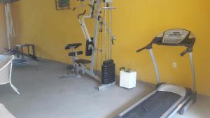 a gym with three exercise bikes and a treadmill at RECANTO DE ZEZE in Ilhéus