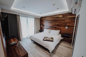 a bedroom with a bed and a wooden wall at La Urumpta Hotel by AKEN Mind in Río Cuarto