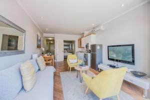 a living room with a couch and a tv at Sea Front Granger Bay Apartment in Cape Town