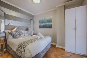 a bedroom with a bed and a closet at Sea Front Granger Bay Apartment in Cape Town