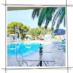 - une table et des chaises à côté de la piscine dans l'établissement Hotel San Marco, à Bardolino