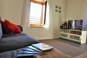 uma sala de estar com um sofá e uma televisão em Chalet Laghel em Arco