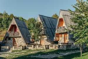 ein Blockhaus mit schwarzem Dach in der Unterkunft Eco Village Nevidio in Pošćenje