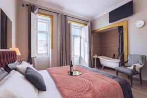 um quarto com uma cama e uma banheira e uma banheira em Downtown Loulé em Loulé