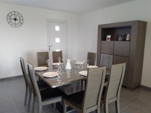 a dining room with a table with chairs and a clock at Maison de vacances près de la mer à Créances in Créances +21 photos