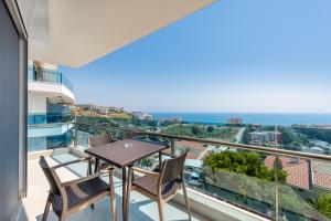 einen Balkon mit einem Tisch, Stühlen und Meerblick in der Unterkunft Elite Luxury Suite & Spa in Alanya