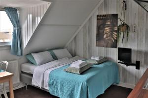 a bedroom with a bed with a blue blanket at Bed & Breakfast Hotel Zandvoort in Zandvoort