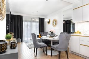een keuken en eetkamer met een tafel en stoelen bij Apartamenty Gardenia Seaside 2 with Sea View by Renters in Dziwnów