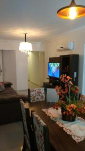 een woonkamer met een tafel en een televisie bij Fabuloso Apto PIRATUBA in Piratuba