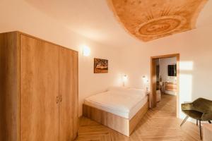 een slaapkamer met een bed en een houten plafond bij Hotel Dymník in Rumburk