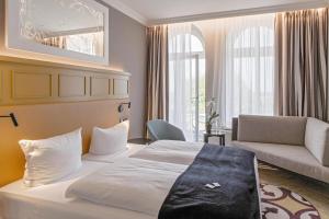 Postel nebo postele na pokoji v ubytování SEETELHOTEL Ostseehotel das Entdeckerhotel an der Ostsee und der perfekte Startpunkt für Ihre Inselabenteuer + 37 fotografií
