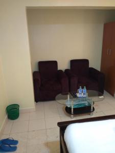 a living room with a couch and a glass table at Crown Hotel Kericho in Kericho