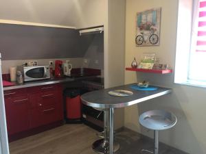 una pequeña cocina con mesa y microondas en Chez claudine, en Favières