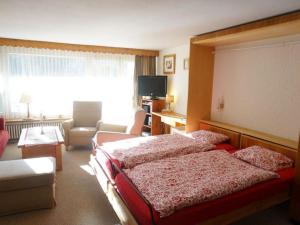 een slaapkamer met een bed en een woonkamer bij Apartment La Sarine 13 by Interhome in Gstaad