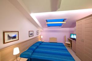 1 dormitorio con 1 cama con manta azul en Sorrento Belvedere B&B, en Sorrento
